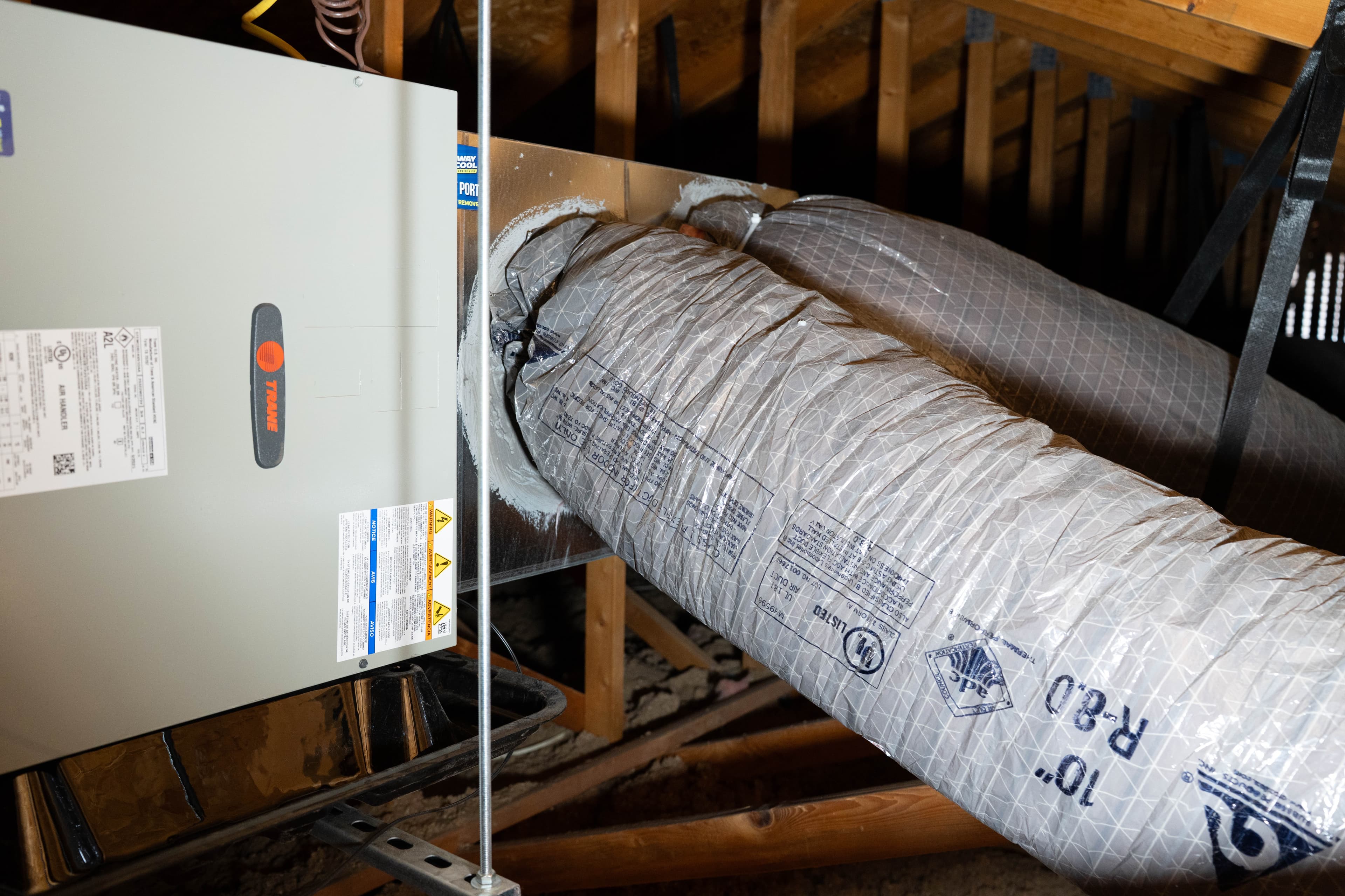 Technician performing duct sealing diagnostics in a Goodyear attic